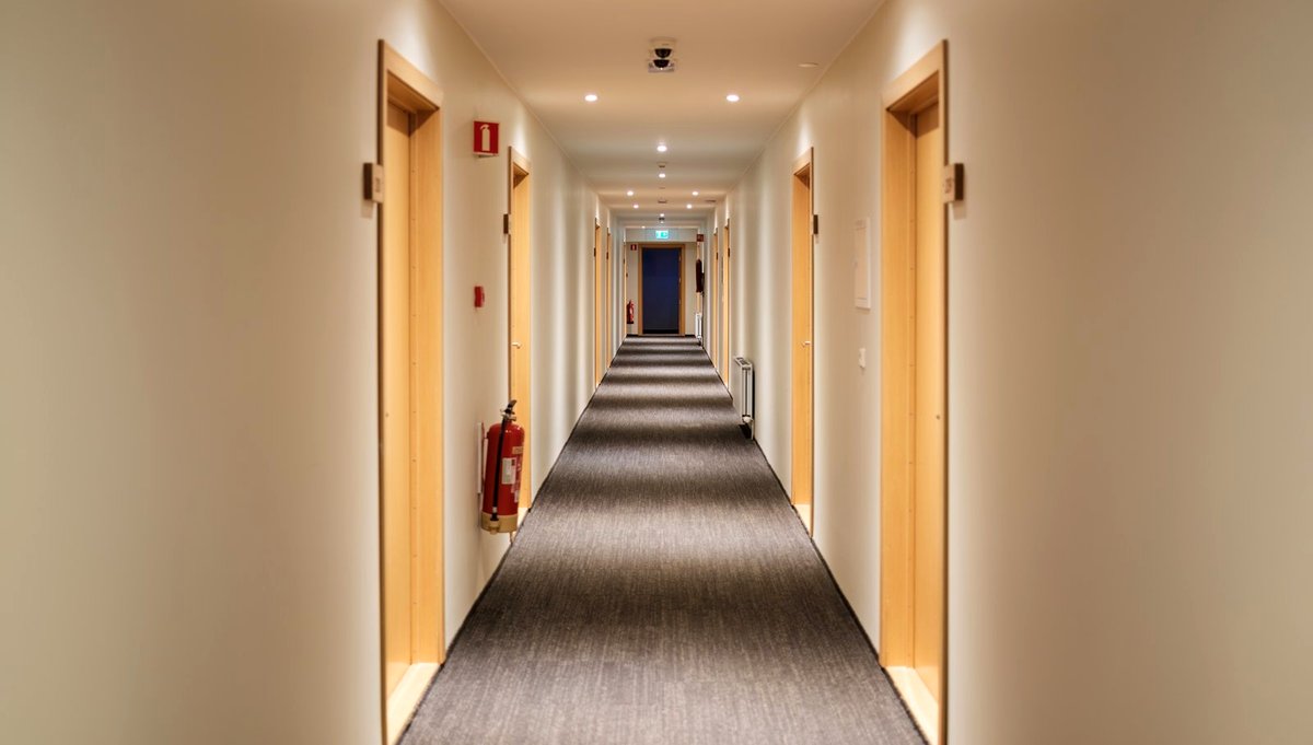 Empty hotel corridor, doors receding