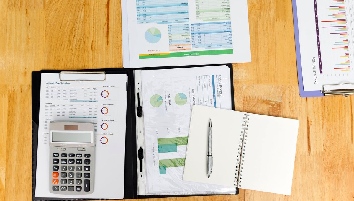 A desk of charts under lamplight